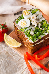 a huge herring sandwich with mayonnaise and quail eggs