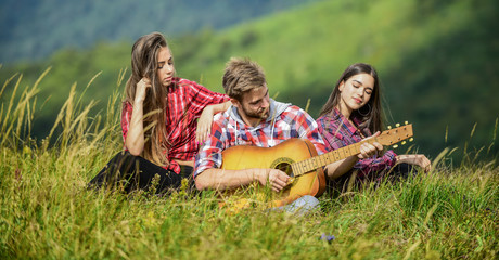 Just friends and guitar. campfire songs. group of people spend free time together. family camping. hiking adventure. happy men and girls friends with guitar. friendship. picnic in tourism camp