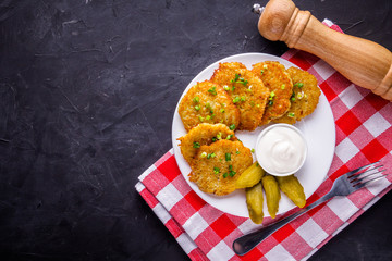 Delicious crispy potato pancakes on dark stone background