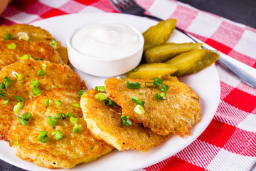Delicious crispy potato pancakes on dark stone background