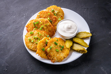 Delicious crispy potato pancakes on dark stone background