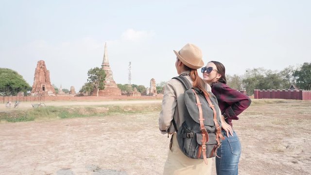 Beautiful Asian Young Women excited Arms Outstretched and embrace friend. She is enjoying in world heritage city Ayutthaya. Freedom woman having fun, traveling on holidays The old town. Slow Motion