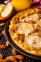 crispy apple galette with almonds on rustic wooden background