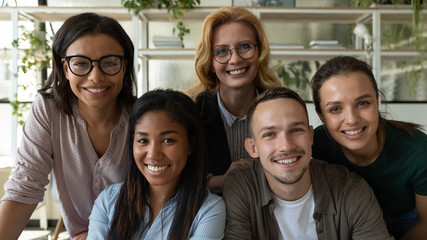 Portrait of diverse multiethnic smiling businesspeople look at camera pose for company group picture together, happy multiracial colleagues coworkers show unity and support cooperating at workplace