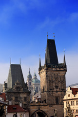 Naklejka premium view from the Charles Bridge landmark looking towards Lesser Town with the bridgetower in the foreground and St. Nicholas church in the background, Prague, Czech Republic