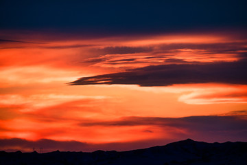 Dramatic sunset clouds over mountain silhouette