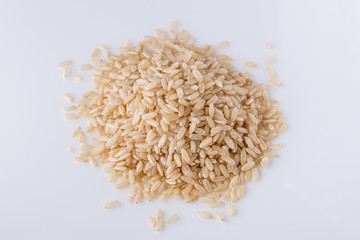 raw brown rice on white acrylic background