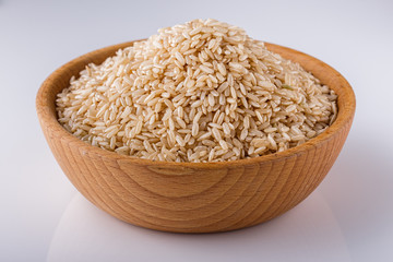 raw brown rice on white acrylic background