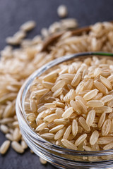 raw brown rice on a dark stone background