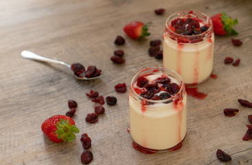 white yogurt with red fruits in the glass jar