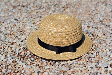 Fototapeta na wymiar Straw hat on sand, sun protection concept. Women's beach accessories or summer outfit on a sandy background.