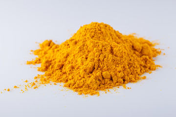 natural turmeric powder on white acrylic background