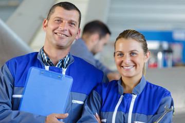 portrait of a man and woman wearing blue overalls