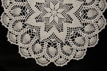 crocheted napkins, white lace on a black background