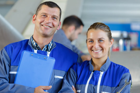 Portrait Of A Man And Woman Wearing Blue Overalls