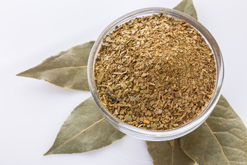 ground dried bay leaf on white acrylic background