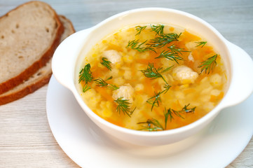 Chicken soup with meatballs and pasta on the table