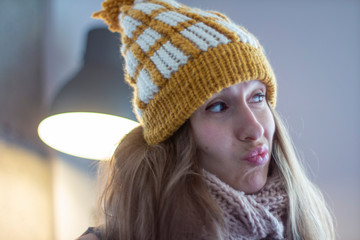 Close portrait of young woman with long hair in yellow hat with scarf
