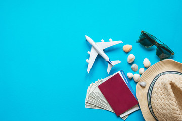 Travel accessories and objects on a blue background with a top view and copy space. Airplane and...