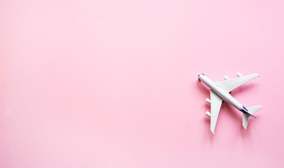 Toy plane on a pastel pink background with top view and copy space. Travel  concept background.