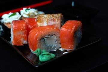rolls and sushi on a black plate.traditional Japanese dish