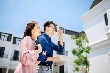 Caucasian couple laughing joyfully at new house