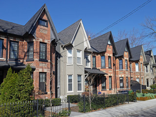 Fototapeta na wymiar Street with row of narrow brick houses with gables