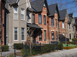 Street with row of narrow brick houses with gables
