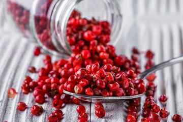 pink peppercorns on white wooden rustic background