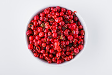 fragrant pink peppercorns on white acrylic background