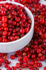 fragrant pink peppercorns on white acrylic background
