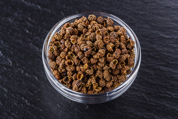 Sichuan pepper on a dark stone background