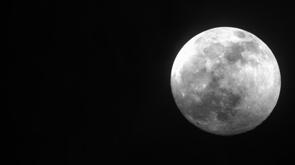 the moon is bright in the dark sky.