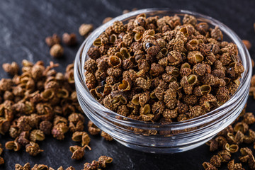 Sichuan pepper on a dark stone background