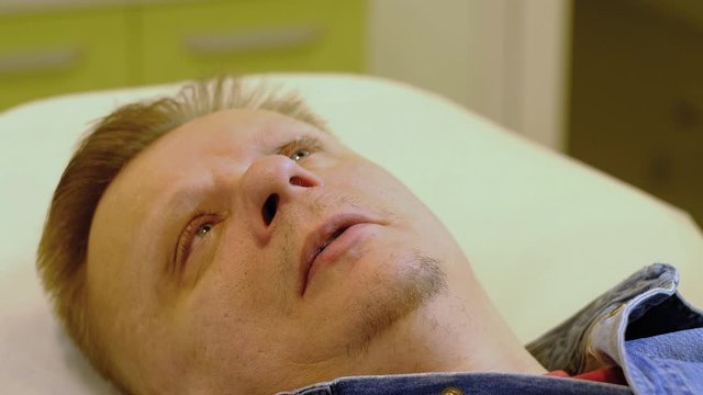 a man lies and prepares for a medical procedure