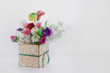 Passover background with spring flower bouquet in matza box with copy space. Happy Passover Spring...