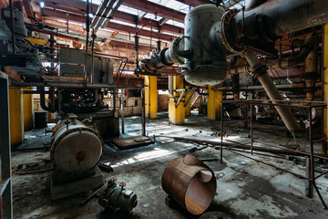 Old rusty Industrial tanks connected by pipes connected with valves in abandoned chemical factory