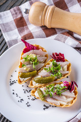 delicious snack tartlets on rustic wooden background