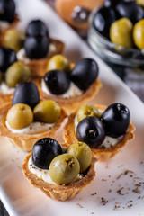 delicious snack tartlets on rustic wooden background