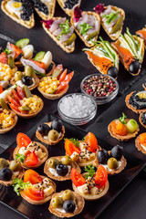 delicious snack tartlets on dark stone background