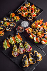 delicious snack tartlets on dark stone background