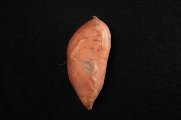 Still earthy sweet potato on a black background