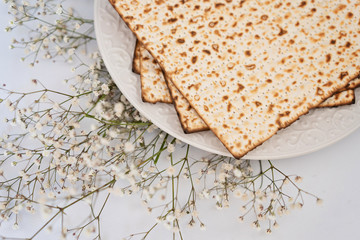 Passover background with matzoh and spring flower ranunculus. Top view with copy space. Happy Passover Spring Festive season greeting card. Jewish holidays arrangement