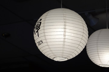 Close up white round Japanese paper lantern at Japanese restaurant. This chinese character(Kanji) "禪" means Zen, which is slang for feeling peaceful and relaxed.