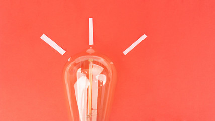 Flat lay of light bulb with red background