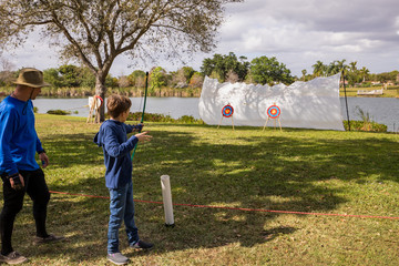 Boy doing archery in a park