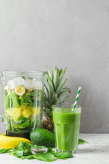Glass of green smoothie detox with fresh juicy ingredients in blender for making healthy drink. vegan cooking concept