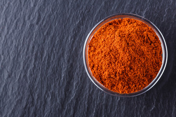 aromatic spicy chilli powder on a dark stone background