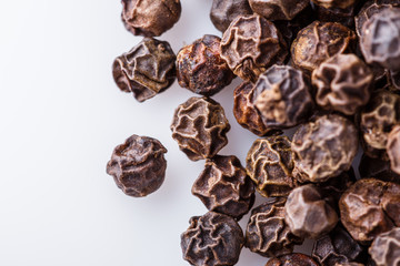 fragrant black pepper on white acrylic background