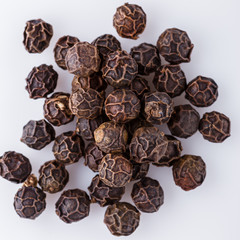 fragrant black pepper on white acrylic background